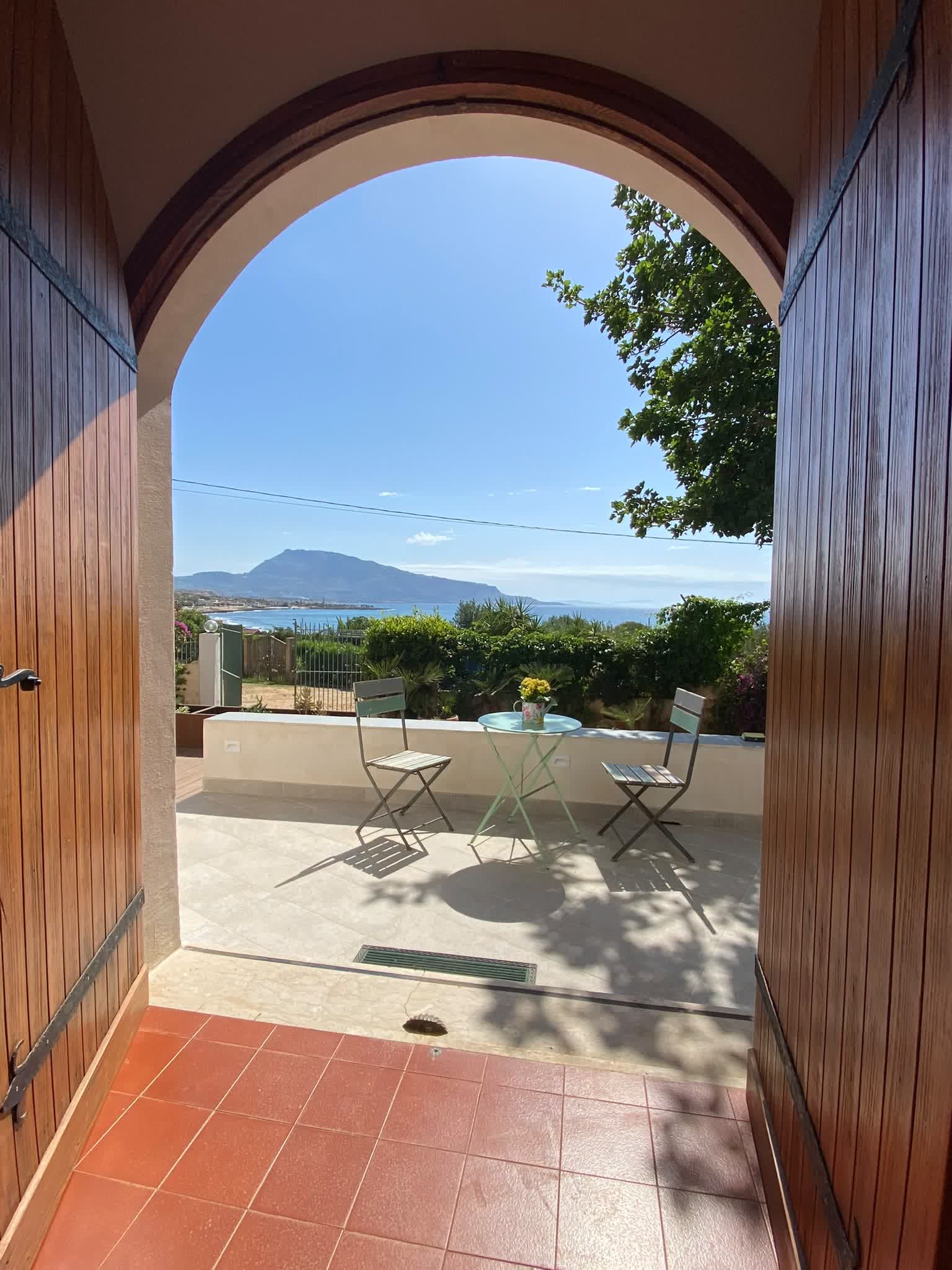 Holztür, geöffnet zur Terrasse mit Blick auf die Bucht von Cornino