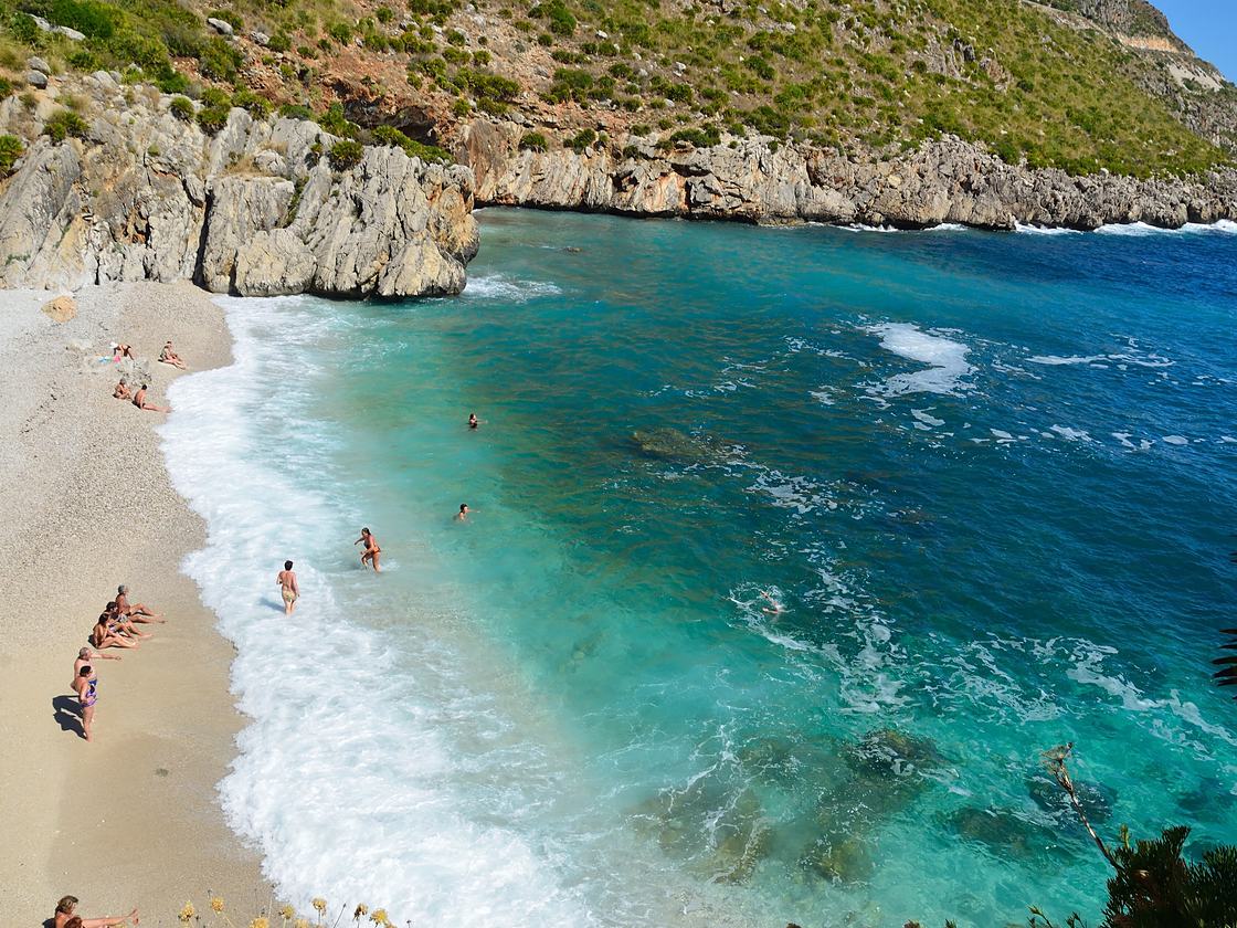 Eine Bucht mit weißen Kieseln und türkisem Meer im Zingaro-Reservat