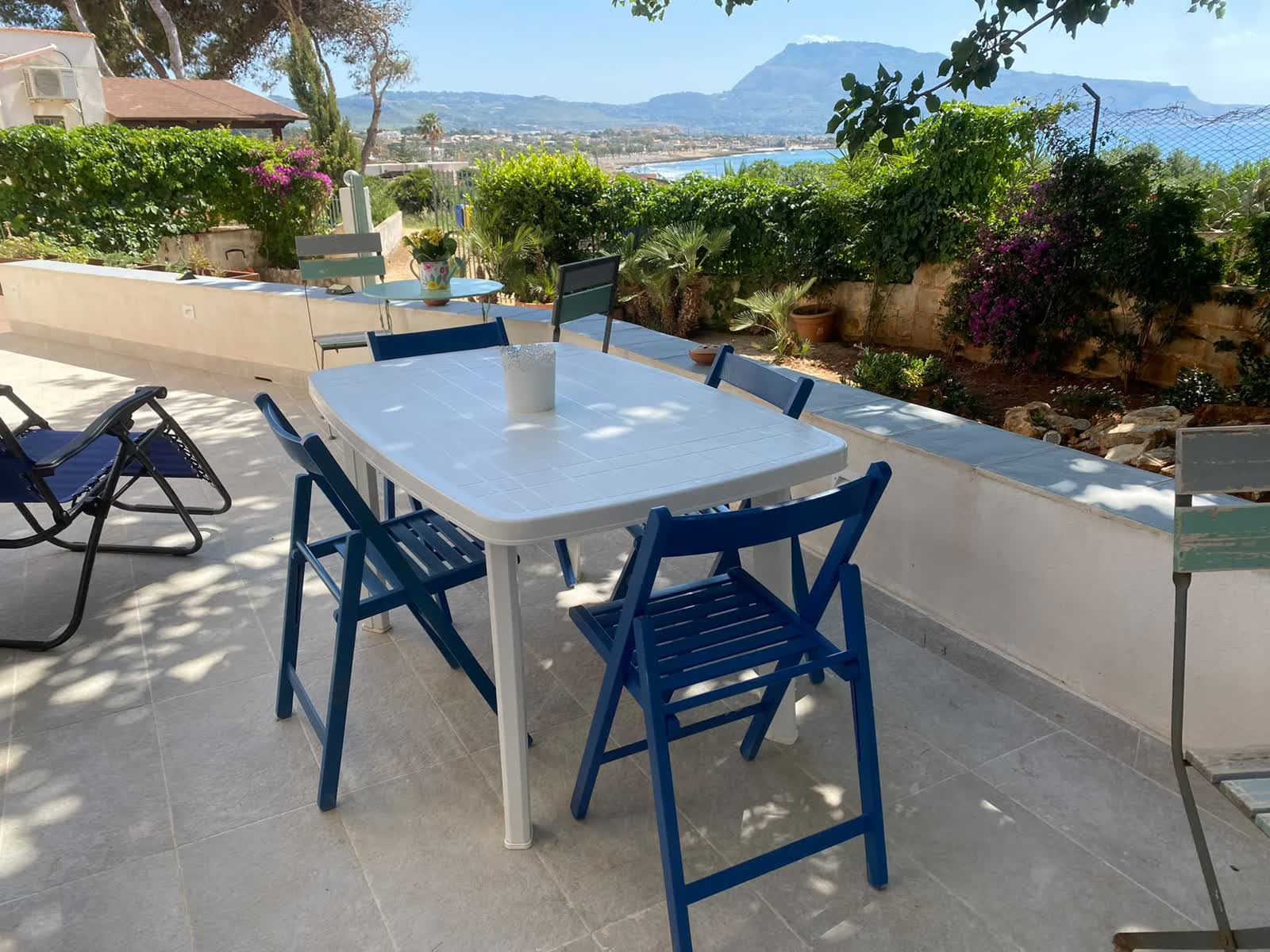 Terrasse mit Tisch, Bougainvillea und Blick auf das Meer von Cornino